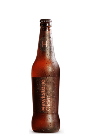 Brown glass beer bottle with condensation droplets on the surface; side label is visible but unreadable.